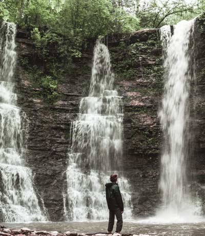 image of man standing in front of waterfalls